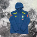 Veste imperméable du Brésil bleue Drip Seleção vue de face complète, capuche relevée et zip intégral