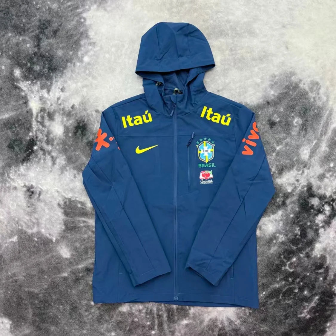 Veste imperméable du Brésil bleue Drip Seleção vue de face complète, capuche relevée et zip intégral